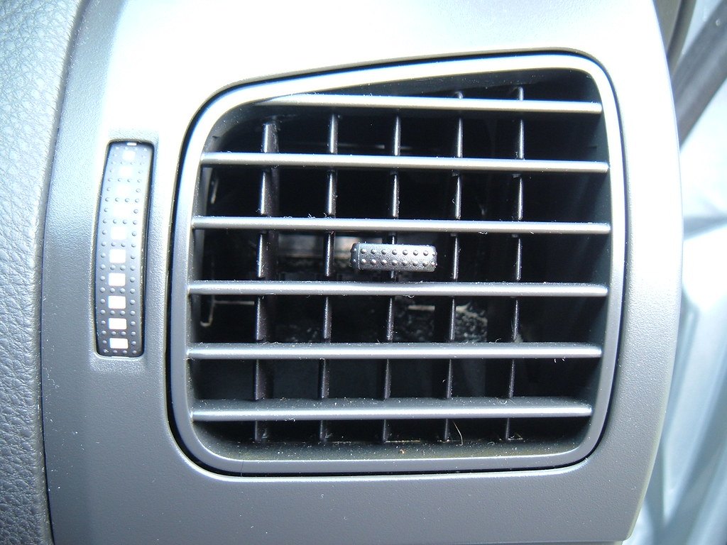 Close-up of a car dashboard air vent with adjustable louvres