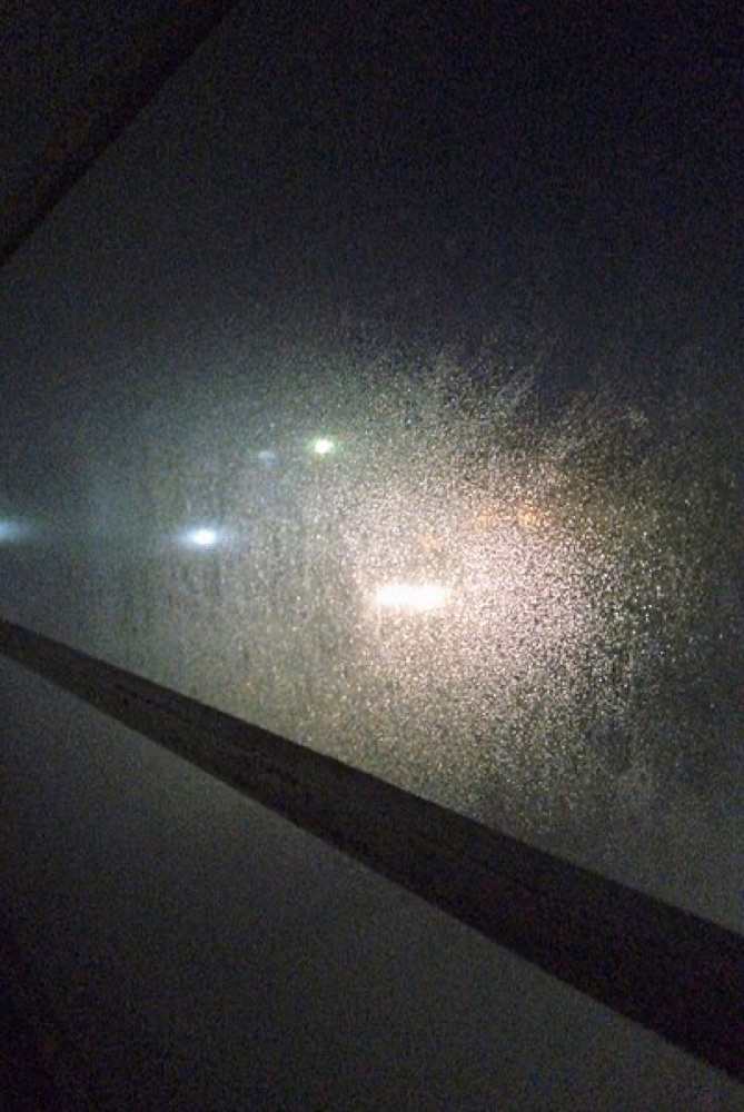 Water condensation beaded and running down the inside of a window pane, the same process that wets a cold basement wall