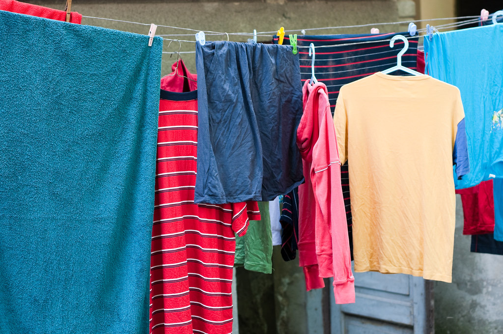 Serviettes, t-shirts et shorts suspendus à une corde à linge en plein air à la lumière du jour